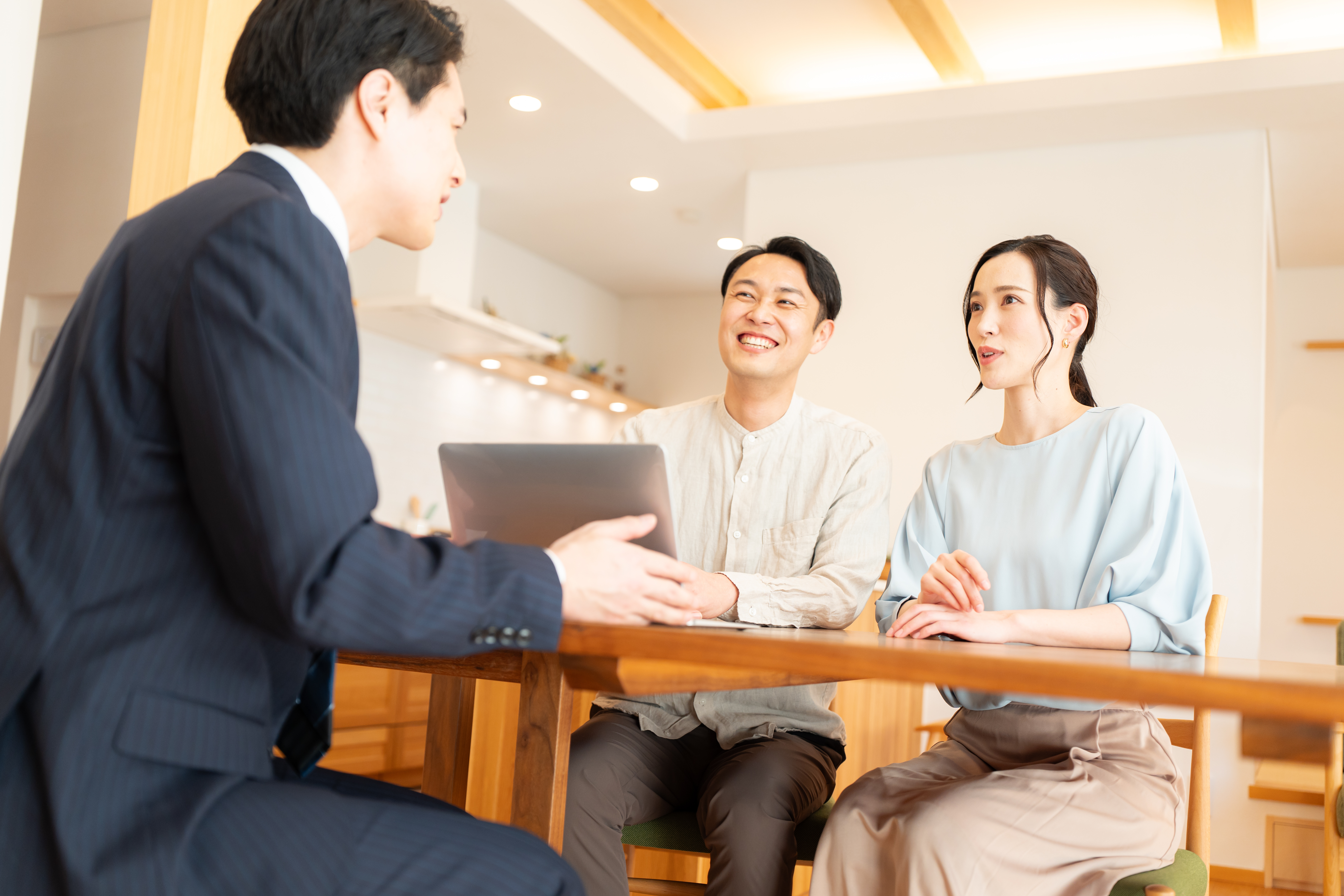 スーツ姿のビジネスマンに営業を受ける夫婦